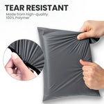 Hands stretching a grey tear-resistant mailing bag made from strong polymer to show its durable design.t grey mailing bag made from strong polymer film