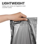 Hand holding a grey lightweight self-seal mailing bag used for postage and courier packaging.